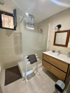 een badkamer met een wastafel, een toilet en een spiegel bij Le petit prince in Balaruc-les-Bains