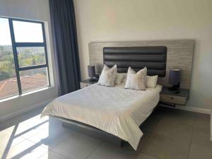 a bedroom with a large white bed with two lamps at 11 @ 7 on Middle Sandton in Johannesburg