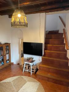 ein Wohnzimmer mit einer Treppe und einem Flachbild-TV in der Unterkunft Casa Félix in Linares de la Sierra
