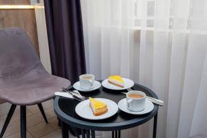 uma mesa com duas fatias de bolo e duas chávenas de café em Lavender Airport Hotel em Arnavutköy