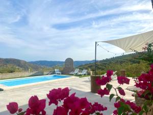 eine Villa mit einem Pool und rosa Blumen in der Unterkunft Casa Las Herriza By Solymar Holiday in Alcaucín