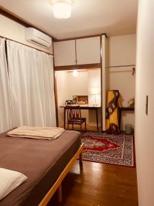 a bedroom with a bed and a desk with a chair at 海に恋する泊まれる喫茶店 ポパイ in Iyo