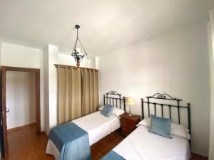 1 Schlafzimmer mit 2 Betten und einem Kronleuchter in der Unterkunft Casa Las Herriza By Solymar Holiday in Alcaucín