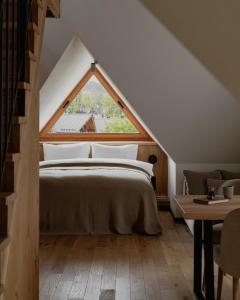 a bedroom with a bed with a large window at Stary Niedźwiedź in Zakopane
