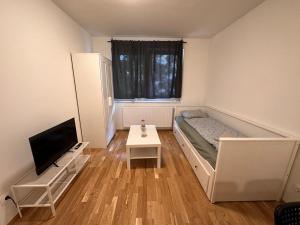 a small room with a bed and a tv at MUZETA11 - Modern Town Apartment with Balcony in Vienna