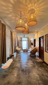 a large living room with two chandeliers and chairs at Happiness Beach Resort Siargao in General Luna