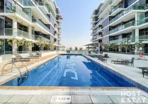 a swimming pool in front of a building at Studio in Golf Vista, Damac Hills - Host & Stay in Dubai