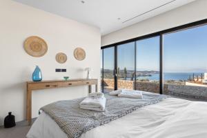 a bedroom with a bed with a view of the ocean at Villa Alchaca - New Magnificent Villa with Infinity Pool & Tennis in Kilada