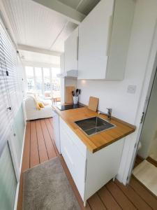 una cucina con lavandino e pavimento in legno di Casa Spinola #SeafrontPenthouse a Paceville