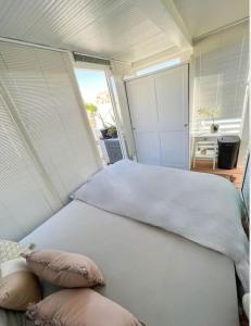 un letto bianco con due cuscini in una camera da letto di Casa Spinola #SeafrontPenthouse a Paceville