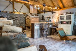 Zimmer mit Holzböden und einer Bar mit Stühlen in der Unterkunft Kuća za odmor Lilium in Ravna Gora