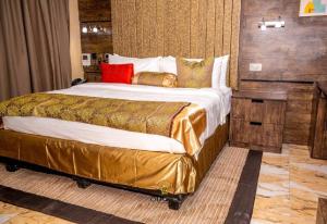 una camera da letto con un grande letto con cuscini rossi di Joker Hotel and Suites a Benin City