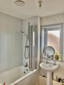 a bathroom with a tub and a sink and a shower at Sunny apartment by the river in Kelso