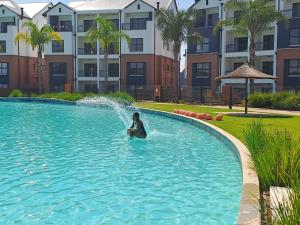 una persona en una piscina con una fuente de agua en Joy Apartment@The Blyde, en Pretoria