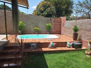 a swimming pool in a backyard with a wooden deck at Casa com piscina com hidro in Lagoa Santa