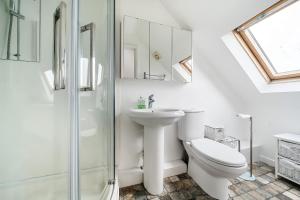 a bathroom with a toilet and a sink and a shower at Sandy Feet Retreat in South Hayling