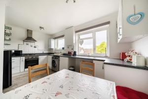 a kitchen with a table and chairs in a room at Sandy Feet Retreat in South Hayling