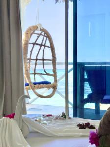 a baby bed with a swing in front of a window at Equalia boutique hotel in Jambiani