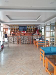 a lobby with tables and chairs and a bar at Dhikidada Resort in Pokhara