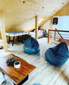 a room with a ping pong table and blue chairs at Beskidzki Zakątek Krynica-Zdrój in Krynica Zdrój