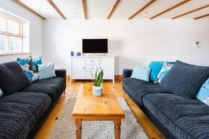 un soggiorno con 2 divani e una TV di Large converted barn in peaceful, rural location a Hambleton