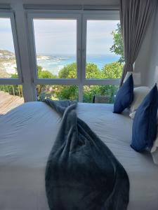 a bedroom with a bed with a view of the ocean at Swept Away B&B - No-Loadshedding in Yzerfontein