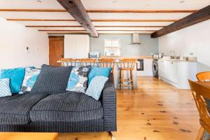 a living room with a couch and a kitchen at Large converted barn in peaceful, rural location in Hambleton