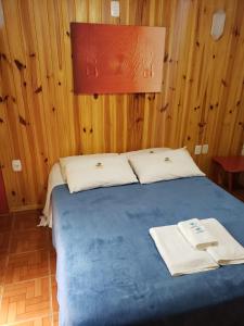 a bedroom with a blue bed with two towels on it at Pousada da Chacara in Nova Petrópolis