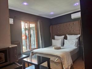 a bedroom with a large bed and a window at Mino Guest House in Pietermaritzburg