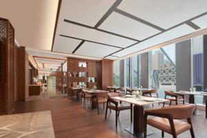 un restaurant avec des tables et des chaises et une grande fenêtre dans l'établissement Baotou Marriott Hotel, à Baotou