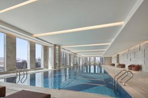 a swimming pool in a building with windows at Baotou Marriott Hotel in Baotou