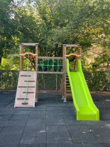 a playground with two swings and a slide at L'enclave 4/6 personne in Estavar