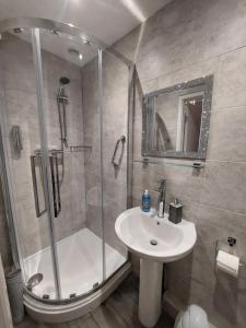 a bathroom with a shower and a sink at Westbrook Lodge Guest House in Margate