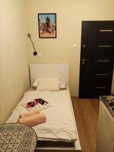 a small bed in a room with a black door at Little Zrin Rooms in Zagreb