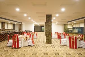 a banquet hall with white tables and red chairs at Country Inn Vrindavan in Vrindāvan