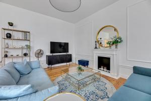 a living room with a blue couch and a fireplace at Lion Apartments -TOKIO Premium Apartment at the Sopot Center in Sopot