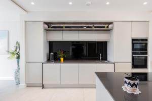 a kitchen with white cabinets and a counter top at Curran Gate Luxury Serviced Apartments, Portrush in Portrush +18 photos
