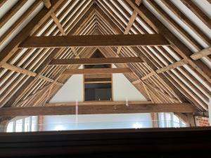 a view from inside a timber frame barn with a window at Grange Farm Barn, Filby in Filby