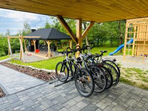 eine Gruppe von Fahrrädern, die unter einem Pavillon mit Spielplatz geparkt sind in der Unterkunft Beskidzki Zakątek Krynica-Zdrój in Krynica-Zdrój
