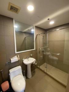 ein Bad mit einem WC, einem Waschbecken und einer Dusche in der Unterkunft Penthouse at Portovita Towers in Manila