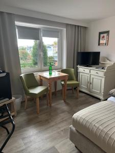 a hotel room with a bed and a table and chairs at Birnbom Warnemünde in Warnemünde