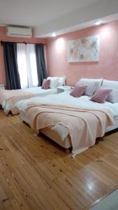 a room with two beds in a room with wooden floors at Bahia Belgrano Suites in Bahía Blanca