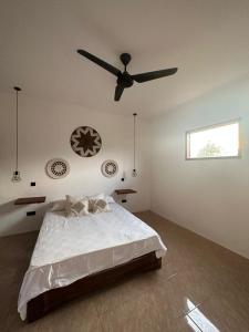 een slaapkamer met een bed en een plafondventilator bij Sekar Kuning Bungalows in Kuta Lombok
