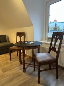 einen Tisch und zwei Stühle in einem Zimmer mit Fenster in der Unterkunft Birnbom Warnemünde in Warnemünde