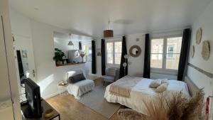 ein weißes Schlafzimmer mit einem Bett und einem Stuhl in der Unterkunft La Duchesse in Versailles