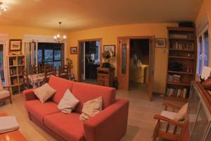 una sala de estar con un sofá rojo en una habitación en Casa el Cerezo Rojo en El Rasillo