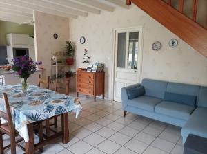 - un salon avec une table et un canapé bleu dans l'établissement Le logis de LANGE apt Les Aigrettes, à Saint-Hilaire-la-Palud