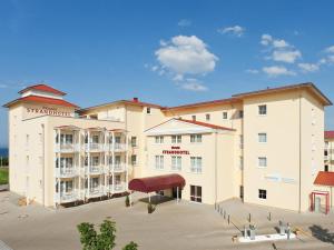 a large apartment building with a large parking lot at Morada Strandhotel Ostseebad Kühlungsborn in Kühlungsborn