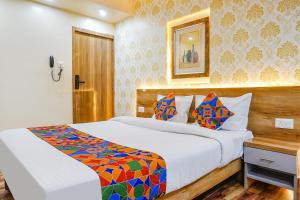 a hotel room with two beds and a mirror at FabHotel Tan Square in Pune