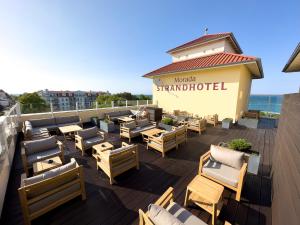a group of chairs and tables on a patio at Morada Strandhotel Ostseebad Kühlungsborn in Kühlungsborn